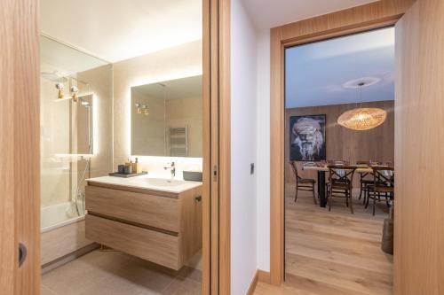 ein Badezimmer mit einem Waschbecken und einem Spiegel sowie ein Esszimmer in der Unterkunft Isard Homes by Select Rentals HUT1-008413 in El Tarter