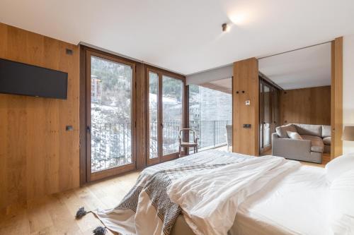 ein Schlafzimmer mit einem Bett und einem großen Fenster in der Unterkunft Isard Homes by Select Rentals HUT1-008413 in El Tarter