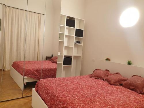 a bedroom with two beds and a mirror at L'Olmo vestito in Teramo