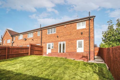 a brick house with a fence and a yard at The Escape in Nottingham