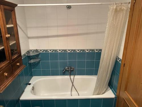 a bathroom with a bath tub with a shower curtain at apartamento Marina in Ribeira