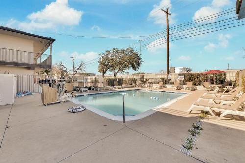 a large swimming pool with lounge chairs around it at Motel 6-Austin, TX - Airport - South in Austin