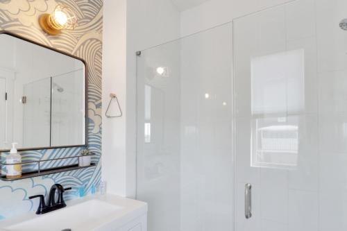 a white bathroom with a mirror and a sink at Simply Adventurous in Mexico Beach