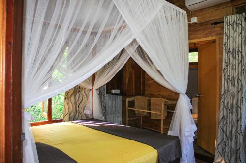 a bedroom with a canopy bed with white curtains at Seasons Four Jungle Treehouse in Matara