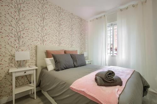 een slaapkamer met een bed met een hoed erop bij Apartamento San Isidro - Elegante y centrico apt. p/5 con Wifi y AC in Alcalá de Henares