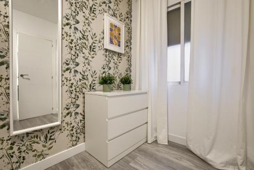 een badkamer met een witte dressoir en een spiegel bij Apartamento San Isidro - Elegante y centrico apt. p/5 con Wifi y AC in Alcalá de Henares