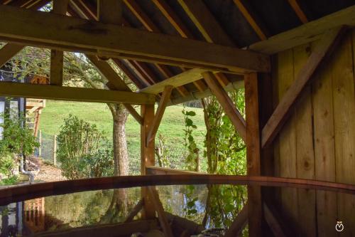 - une vue depuis l'intérieur d'une cabane en bois avec une fenêtre dans l'établissement Colombe - Une Maison du Pays d'Auge - Bain nordique 9P, à Le Mesnil-Eudes