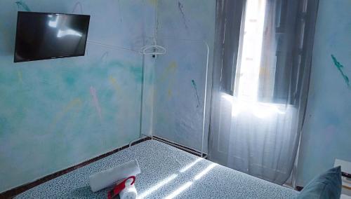 a corner of a room with a shower with a television at SevillaDream in Seville