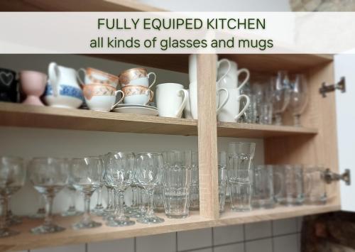 a cabinet filled with glasses and mugs at Stone house with amazing view in Črni Kal