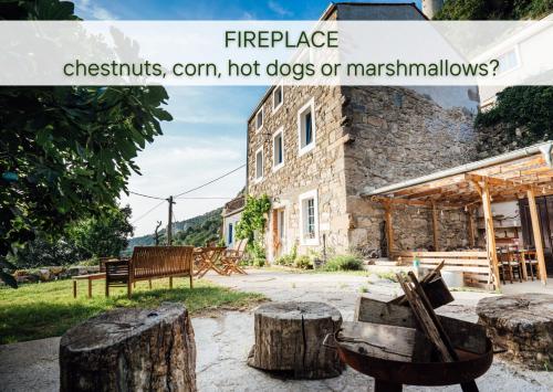 a building with a bunch of logs in front of it at Stone house with amazing view in Črni Kal