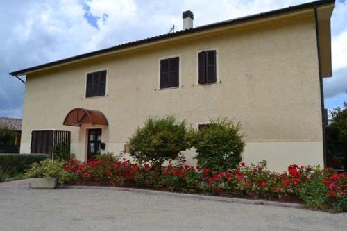 a large building with flowers in front of it at Il Sentiero in Ostra Vetere