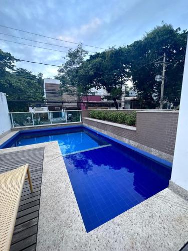 uma piscina com água azul num edifício em Apartamento no Rio vermelho em Salvador