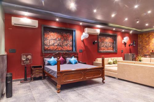 a bedroom with a bed and a red wall at K K RESIDENCY in Yamunānagar