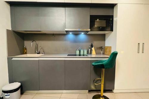 a kitchen with a sink and a green chair at Luxury Loft - 20th Floor / River View in Noida