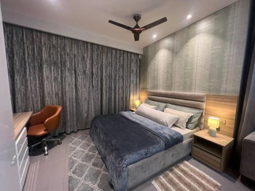 a bedroom with a bed and a ceiling fan at Luxury Loft - 20th Floor / River View in Noida
