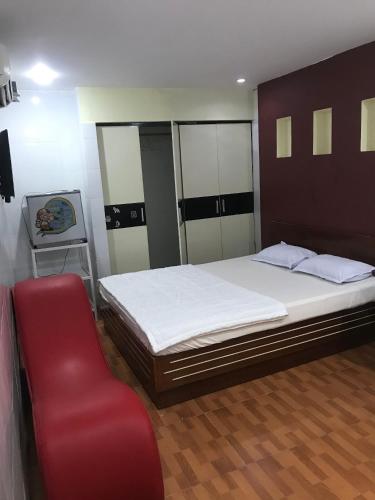 ein Schlafzimmer mit einem großen Bett und einem roten Stuhl in der Unterkunft Khách sạn Tài Phát in Cần Thơ