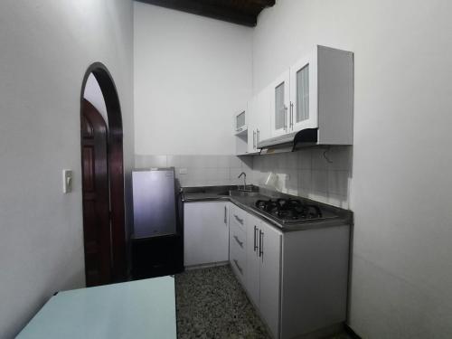 uma pequena cozinha com um fogão e um frigorífico em apartamento barrio jardin em Santa Marta