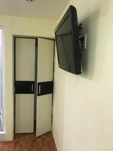 einen Flachbild-TV, der an einer Wand neben einem Schrank hängt in der Unterkunft Khách sạn Tài Phát in Cần Thơ