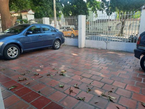 um carro azul estacionado ao lado de um parque de estacionamento de tijolos em apartamento barrio jardin em Santa Marta