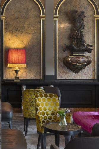 a room with a couch and a table and a painting at Eden Hotel Wolff in Munich
