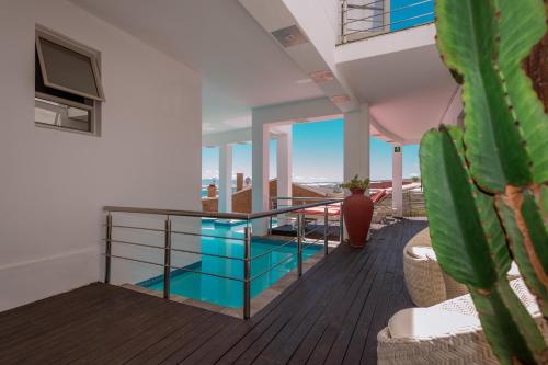 a balcony with a glass railing and a potted plant at Sea Star Lodge in Gansbaai