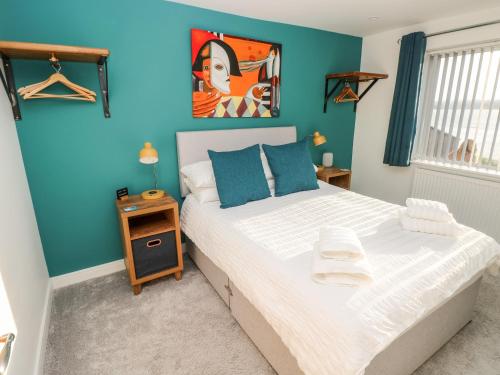 a bedroom with a large bed with blue walls at Cleddau Sound in Milford Haven