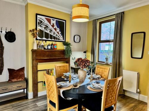 uma sala de jantar com uma mesa e cadeiras e uma lareira em Merton Retreat - City Luxury, Central, Free Parking em Leicester