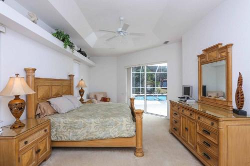 Un dormitorio con una cama, una cómoda y un espejo. en Villa Miami Dream, en South Venice