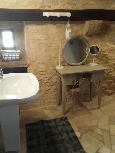 La salle de bains est pourvue d'un lavabo et d'un miroir sur une table. dans l'établissement Maison authentique PERIGORD-QUERCY, à Lavercantière