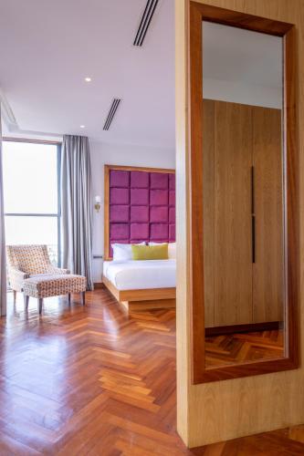 a room with a bedroom with a bed and a mirror at Broadwalk Residency in Nairobi