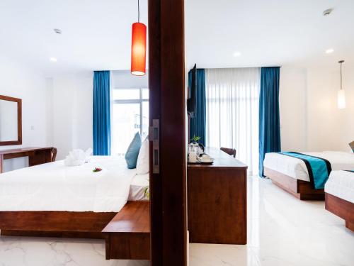 a hotel room with two beds and a bathroom at Le Kree Downtown Hotel in Phnom Penh