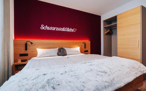 a bedroom with a large white bed with a red wall at Gasthaus Alte Post in Kirchzarten