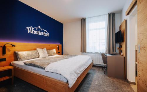 a bedroom with a bed with a blue wall at Gasthaus Alte Post in Kirchzarten