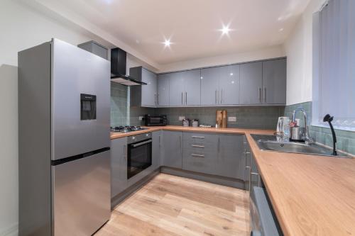 a kitchen with stainless steel appliances and wooden counters at Rooms with Netflix in a shared accommodation, 10 min walk from the stadium in Liverpool