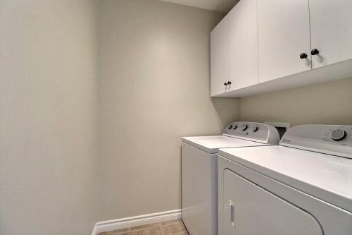 een witte wasruimte met een wasmachine en droger bij Home in Central Moncton WFH NBCC in Moncton