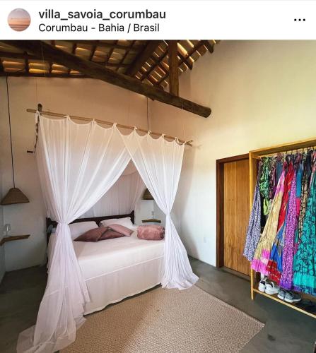 a bedroom with a bed with a canopy at Villa Savoia Corumbau in Corumbau