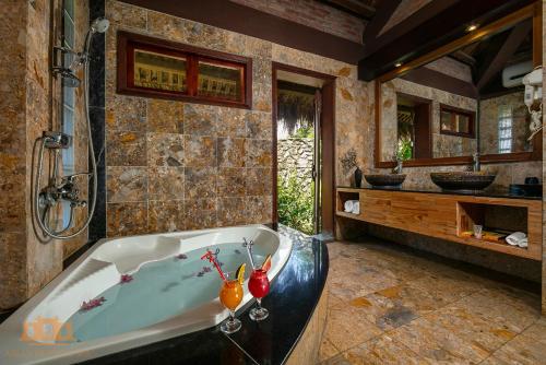 a bathroom with a tub and a sink at Asean Resort - Shiki Onsen & Spa in Hanoi