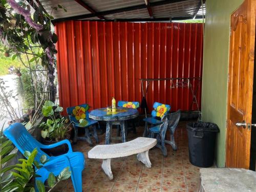 a patio with a table and chairs and a red wall at Star Dormitory in Haad Rin