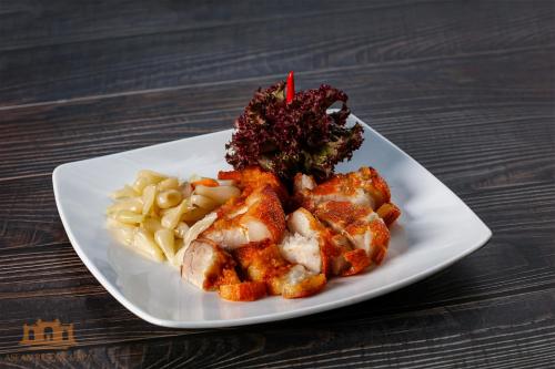 Een bord met kip en pasta op tafel. bij Asean Resort - Shiki Onsen & Spa in Hanoi