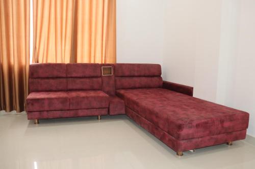 a living room with a red couch and a chair at HOTEL JVS PALACE in Gorakhpur