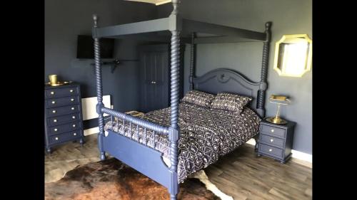 um quarto com uma cama de dossel azul e uma cómoda em Springwood cabin 