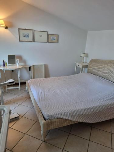 ブレンゾーネにあるAppartamenti Albatrosのベッドルーム1室(ベッド1台、テーブル、椅子付)