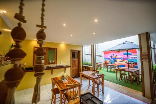 eine offene Küche und ein Esszimmer mit einem Sonnenschirm in der Unterkunft Villa Paihia Jericoacoara in Jericoacoara