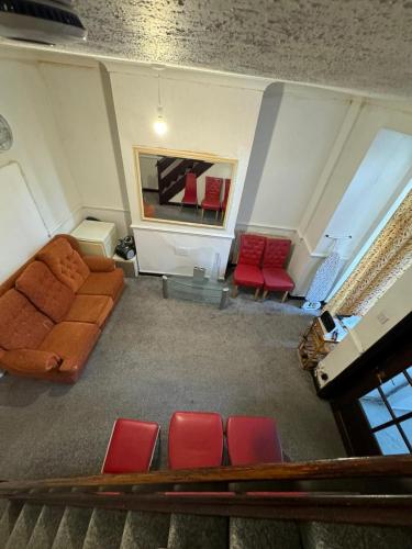 sala de estar con sofá y sillas rojas en 316 Ripponden home en Moorside