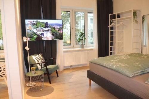 1 dormitorio con 1 cama y TV en una habitación en City Apartment Rudolf 26m2 en Graz