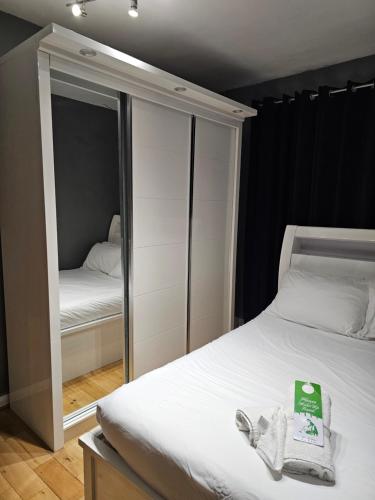 a small bedroom with a mirror and a bed at Umbrella Properties London Woolwich in London