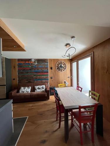 une salle à manger avec une table, des chaises et un canapé dans l'établissement Vip apartment on the ski slopes, à Montgenèvre