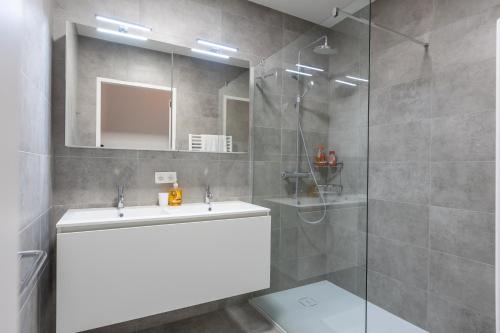 y baño con lavabo y ducha. en Gezellig appartement - Zeeparel - 6 personen - 3 kamers, en Middelkerke