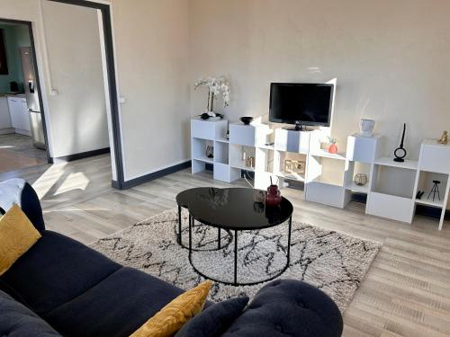 a living room with a couch and a coffee table at Appartement au cœur des alpes in Albertville