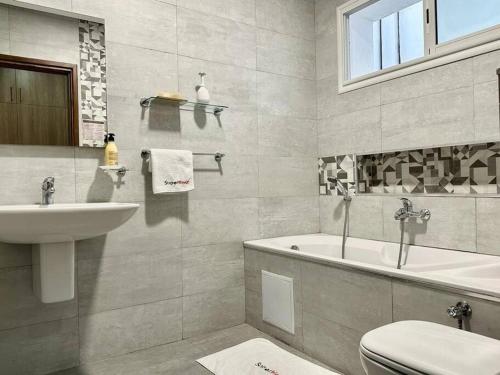 a bathroom with a sink and a tub and a toilet at Saf-Saf Apartement 1 in La Marsa